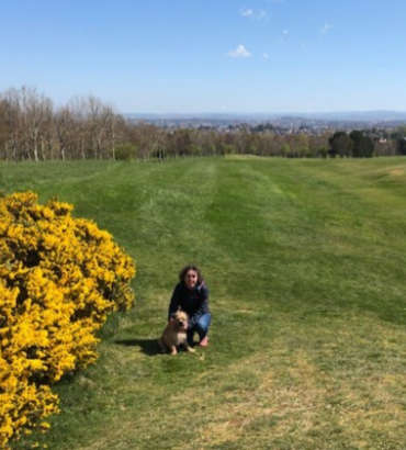 Woman and her dog in a field on a bright sunny day, Edinburgh