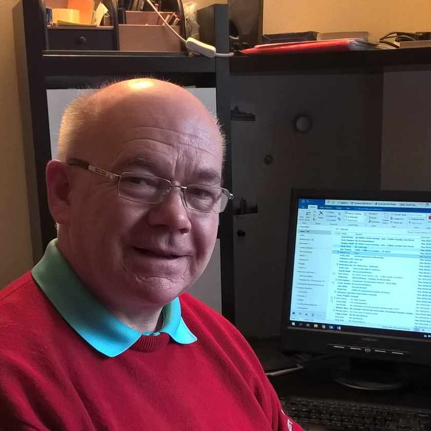 Malcolm Cutt sitting by his computer in his home office, Edinburgh