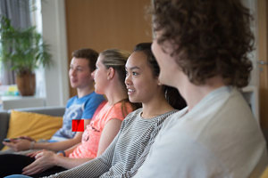A group of Queen Margaret University students sitting on a couch in on-site accommodation