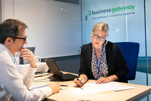 A woman and a man looking at some paper in Queen Margaret University's Business Gateway
