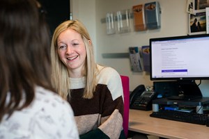 A Queen Margaret University wellbeing advisor talking to a student