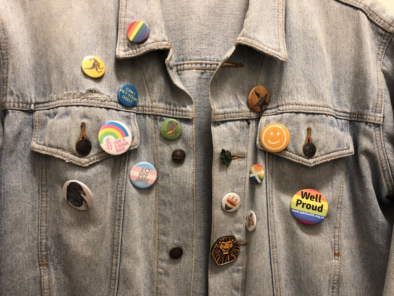 A denim jacket with lots of colourful badges
