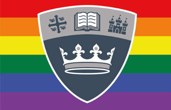 The QMU shield in front of the LGBTQ+ flag