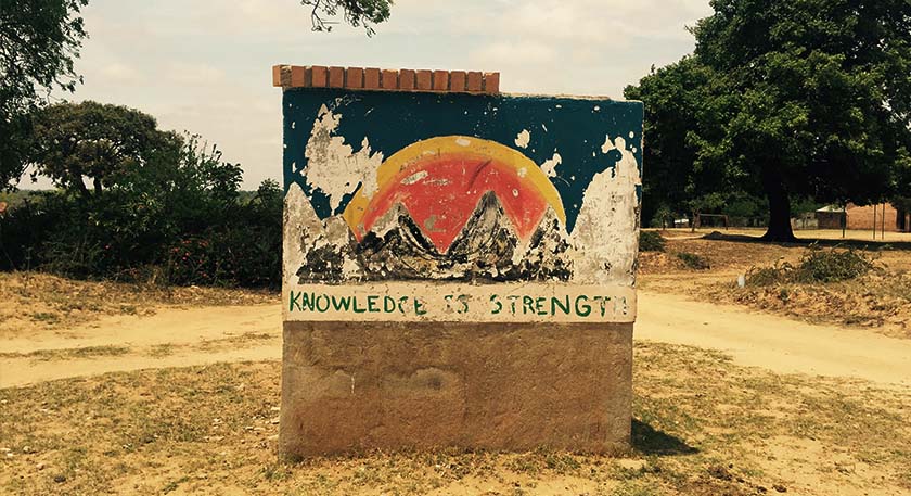 A weathered outdoor hand painted sign with the words "knowledge is power"