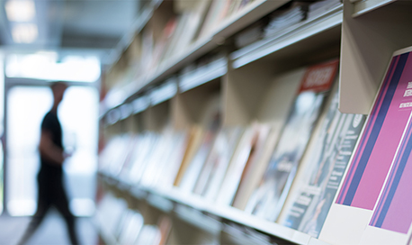 Blurry image of a row of books and leaflets in a library