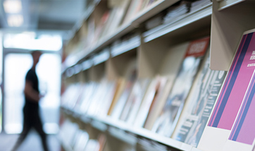 Blurry image of a row of books and leaflets in a library