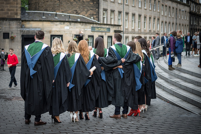 A row of QMU graduands standing in a row wearing their gowns outside Usher Hall