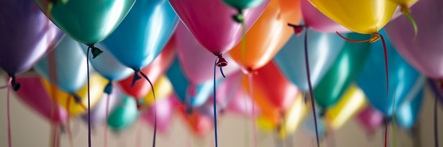 Close up of a bunch of multicoloured balloons full of helium