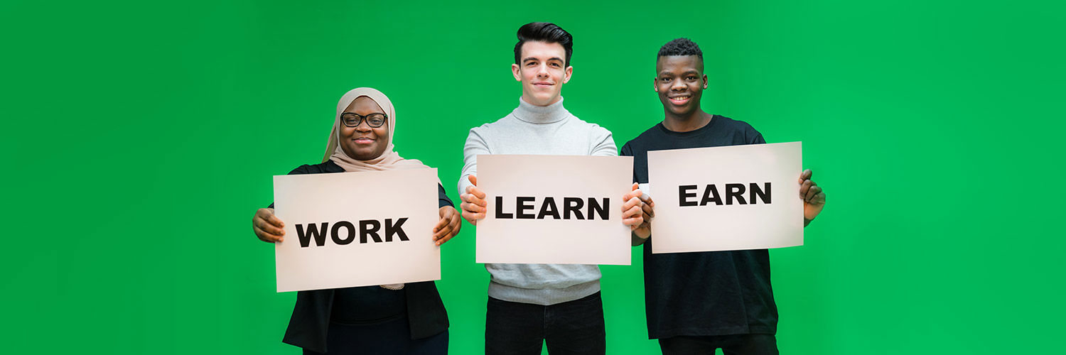Three Queen Margaret University students holding signs with the words "Work", "Learn" and "Earn"