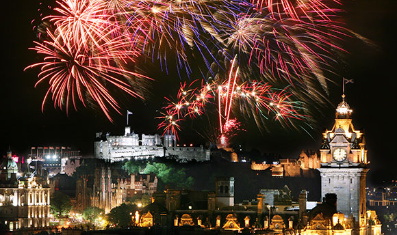 Fireworks setting off above Edinburgh Castle at night time