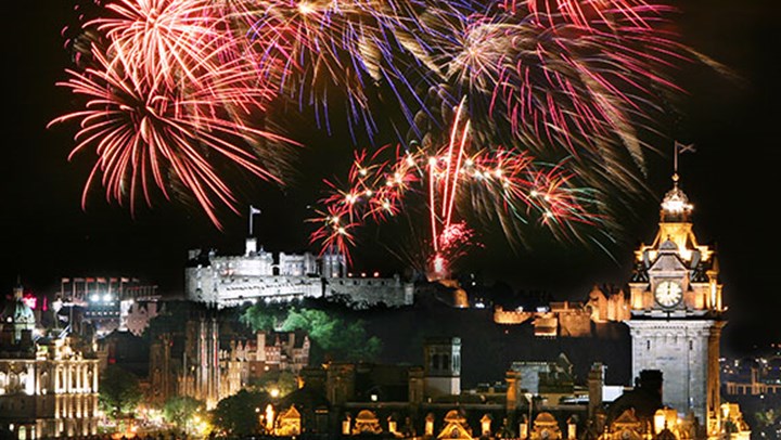 Fireworks setting off above Edinburgh Castle at night time