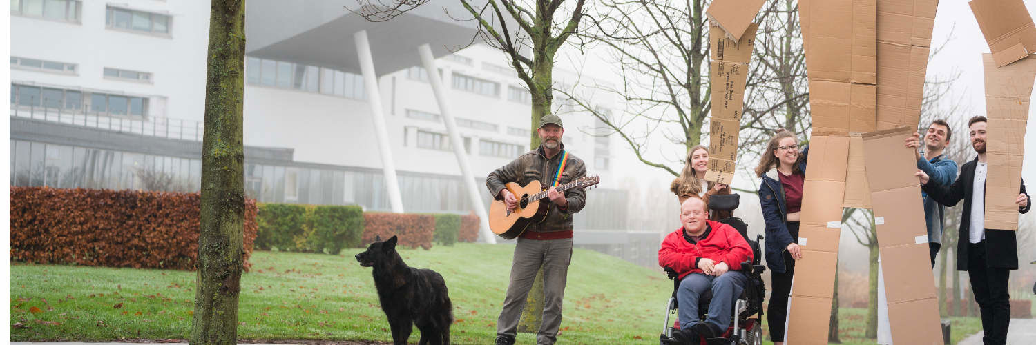 Applied Arts and Social Practice students construct cardboard sculpture and play guitar on campus grounds