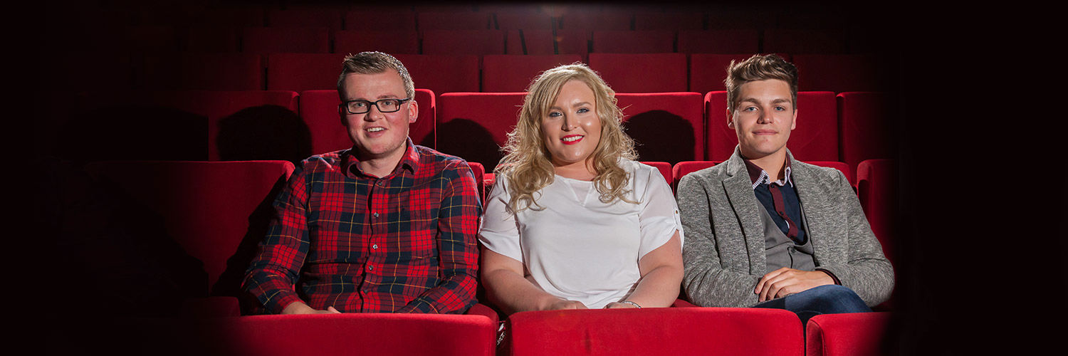 Three Queen Margaret University students sitting in plush red seats at the theatre