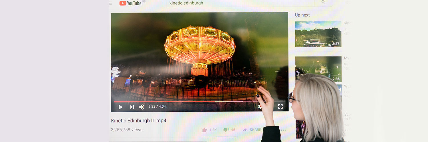Student presenting video of illuminated carousell ride 