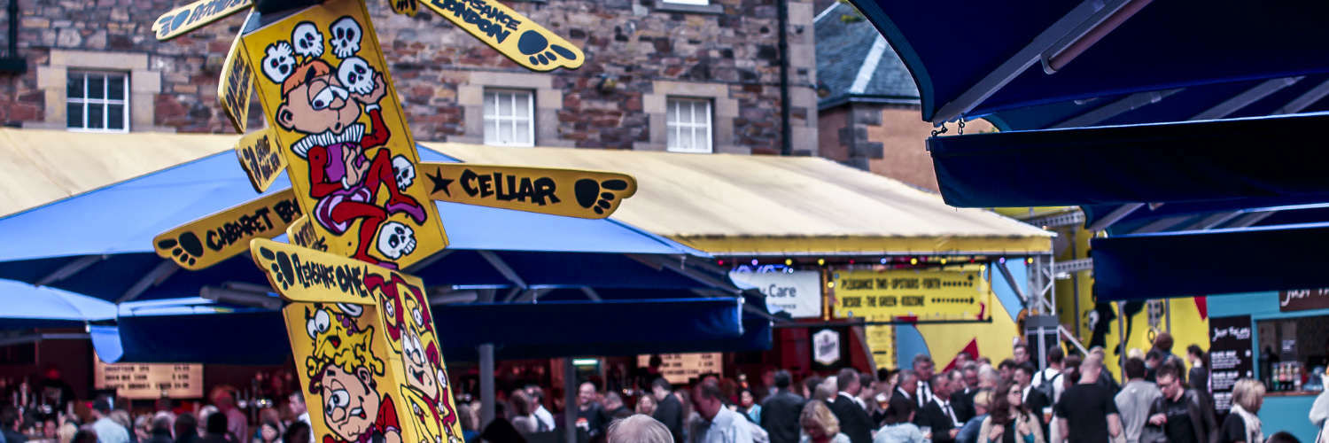 A sign in the crowded Pleasance square during the Edinburgh Festival Fringe