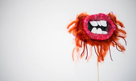A surreal painting of an open mouth with crooked teeth