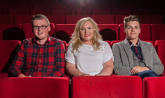 Three Queen Margaret University students sitting in plush red seats at the theatre