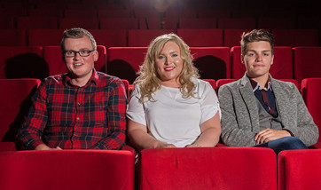 Three Queen Margaret University students sitting in plush red seats at the theatre