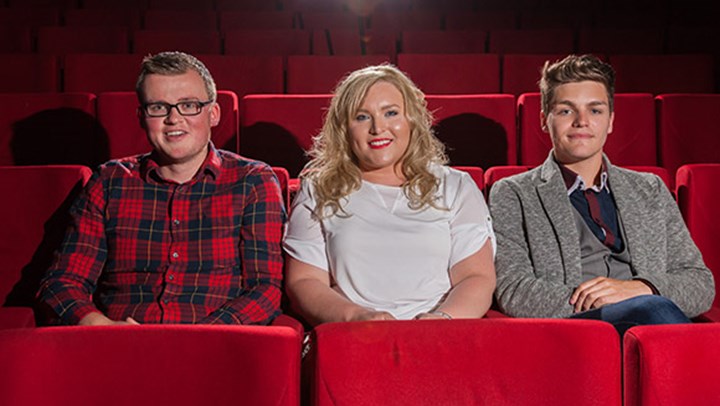 Three Queen Margaret University students sitting in plush red seats at the theatre