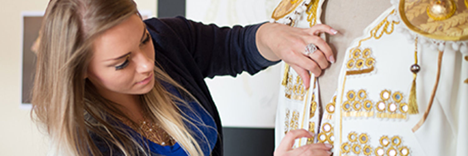QMU Costume Design student creating a gold and white detailed jacket