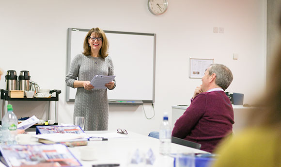 A woman giving a presentation in a corporate boardroom