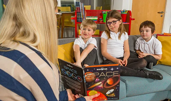 A teacher showing children a picture in a book