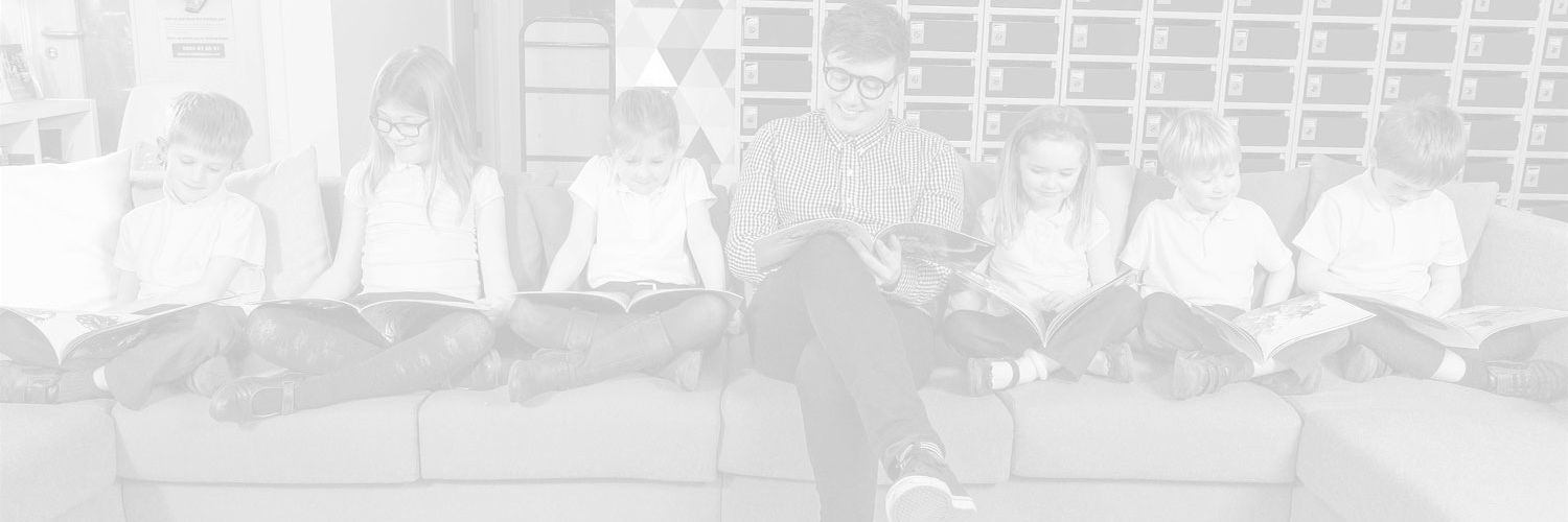 Faded image of a teacher on a sofa with some young students 
