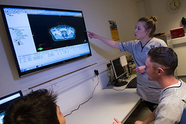 Radiography students examining an X-Ray 