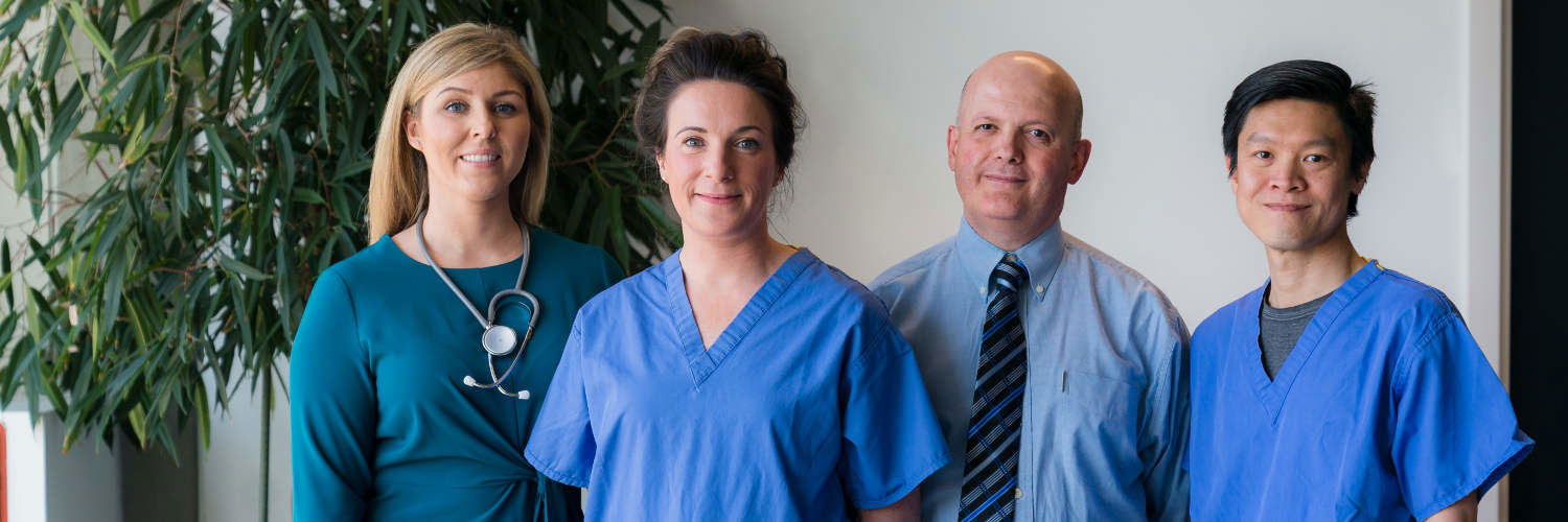 Two lecturers and two student nurses smiling at the camera