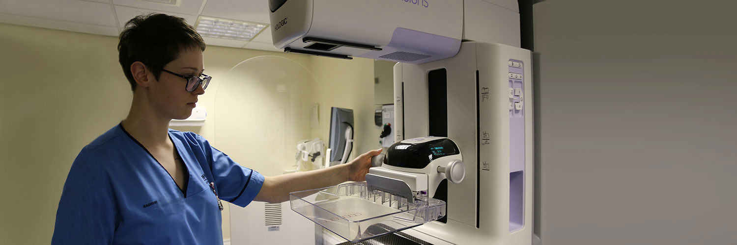 A student nurse standing by a mammography imaging machine