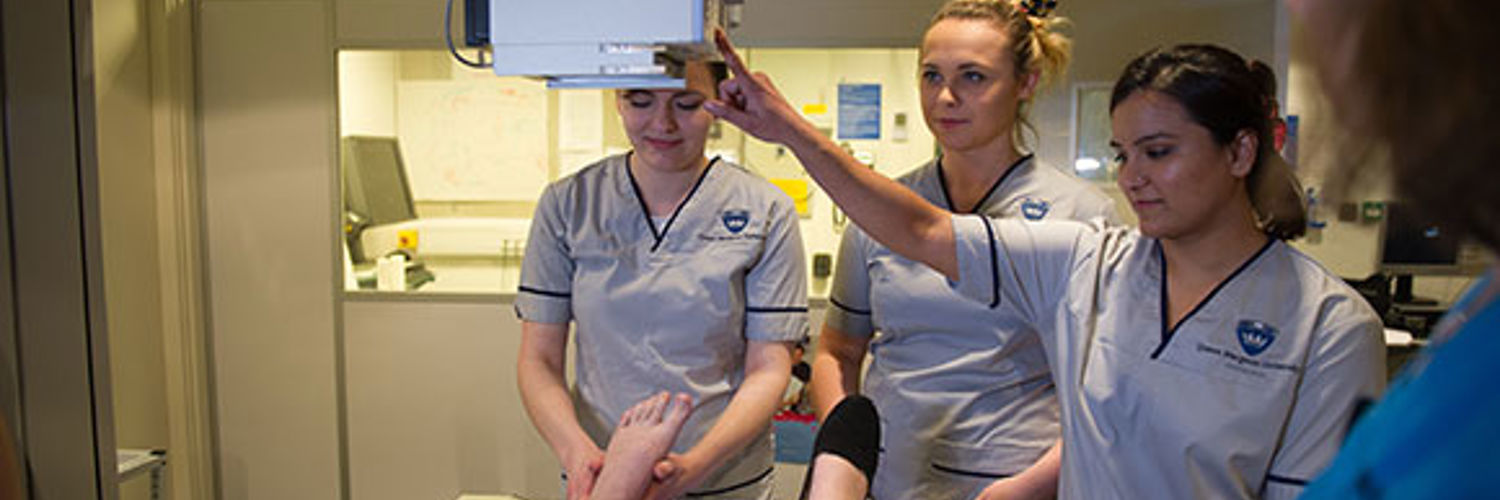 Radiography students directing an x-ray machine over a foot