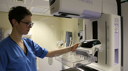 A student nurse standing by a mammography imaging machine