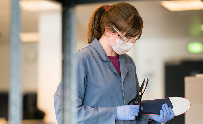 A Queen Margaret University student making shoe insoles