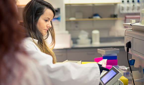 Two students in a laboratory wearing lab coats