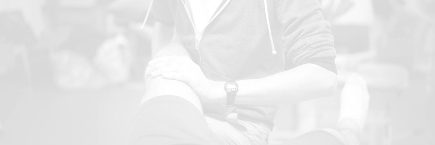 Faded image of a QMU physiotherapy student treating a patient