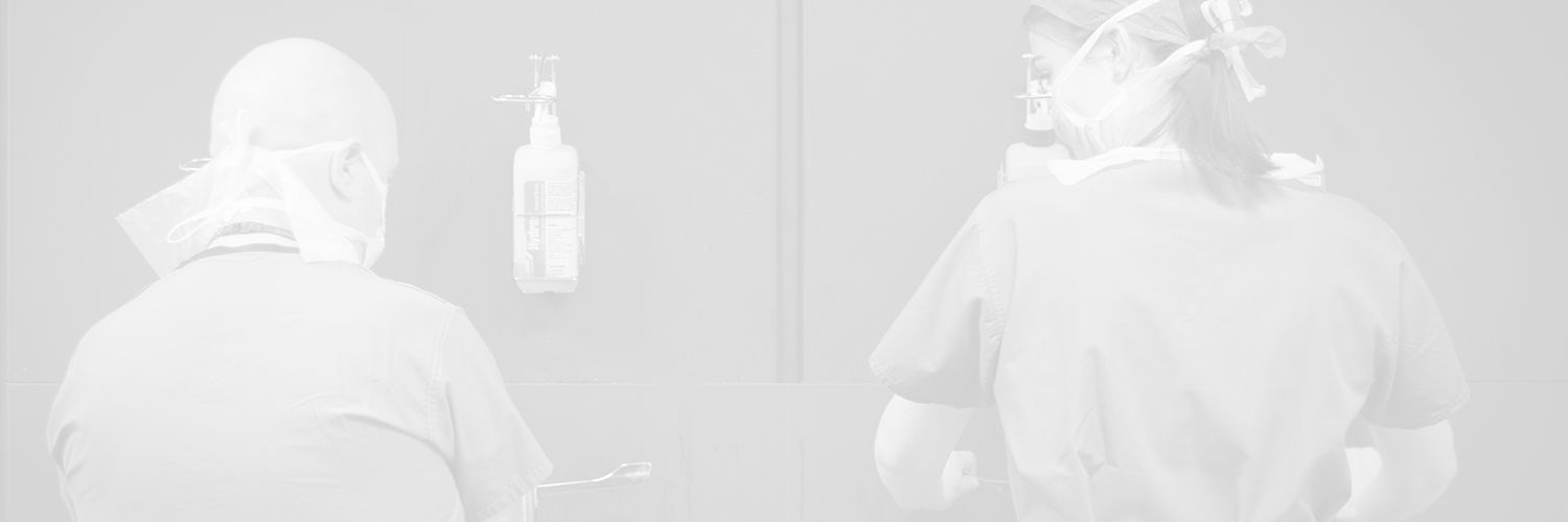 Faded image of two Podiatry students wearing PPE and washing their hands