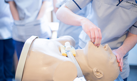 A student nurse practicing unblocking the airways on a resuscitation dummy