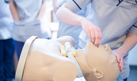 A student nurse practicing unblocking the airways on a resuscitation dummy