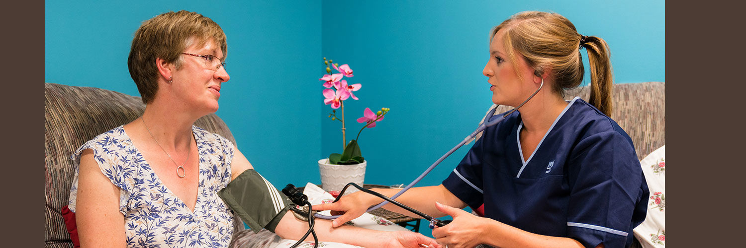 A student nurse taking a woman's blood pressure