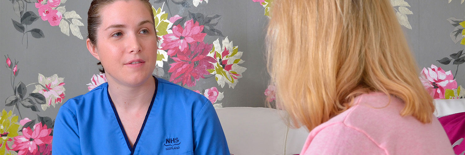 QMU student nurse talking to a patient and taking notes
