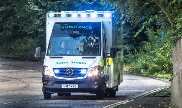 An ambulance driving with its lights on