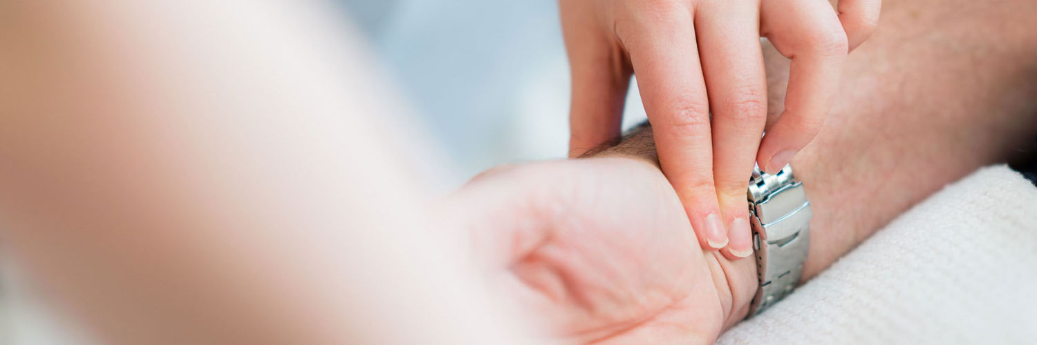 A close up of someone getting their pulse taken on the wrist