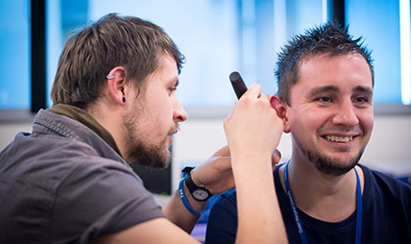 QMU Hearing Aid Audiology student using a piece of equipment to test another student's hearing