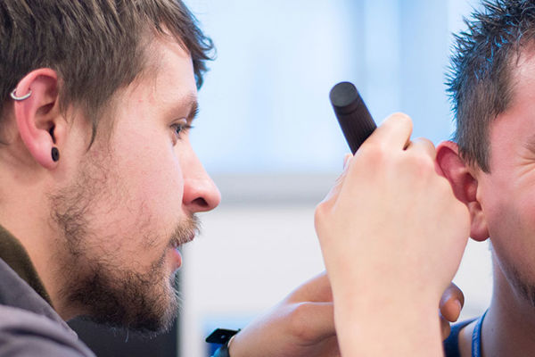 QMU Hearing Aid Audiology student using a piece of equipment to test another student's hearing