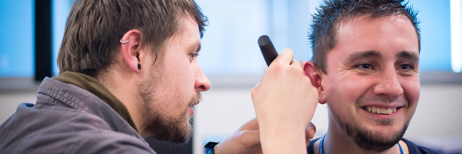 QMU Hearing Aid Audiology student using a piece of equipment to test another student's hearing