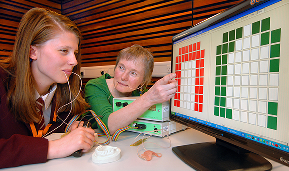 A student & Lecturer with probes in their mouths looking at a screen covered in coloured squares