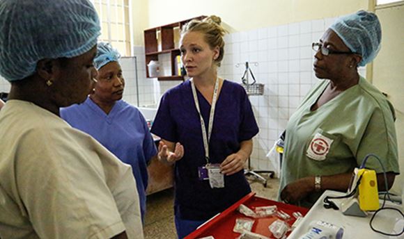 Nurses in scrubs standing together discussing something and looking focussed