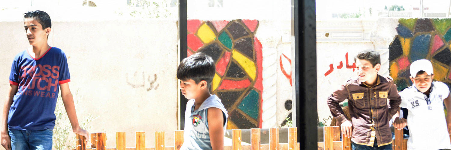 Four children standing outside in the sun