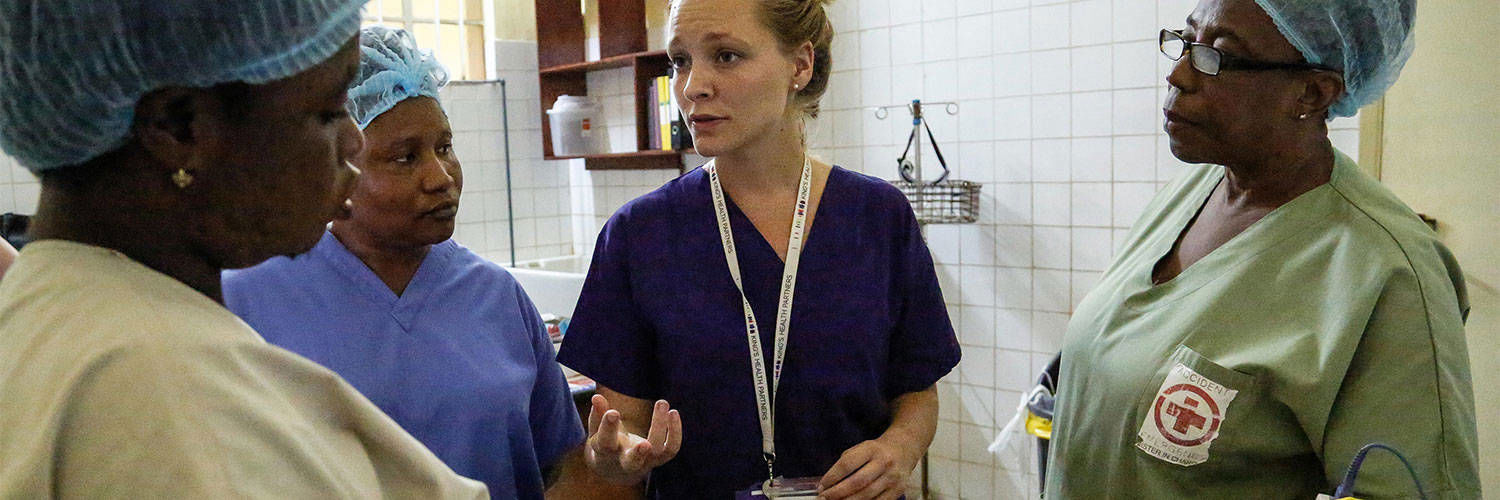 Nurses in scrubs standing together discussing something and looking focussed