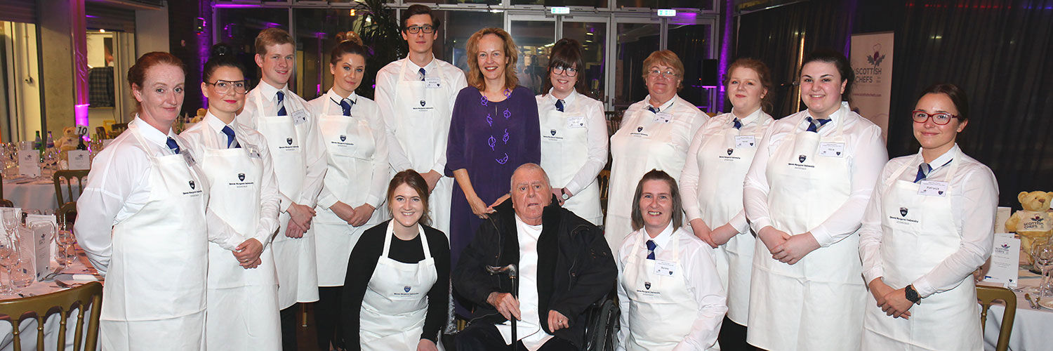 Albert Roux posing with QMU hospitality students